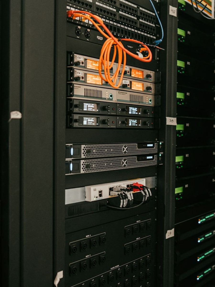 Armadio rack server professionale in produzione: switch ethernet, server enterprise, patch panel e cavi colorati